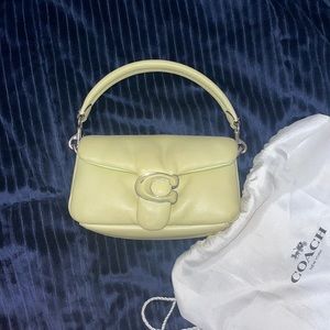 Neon tabby bag from Coach. Good condition. Has a scratch on the letter C.
